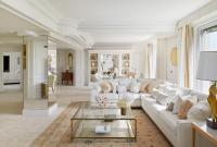 a living room with a white couch and a glass table at Four Seasons Hotel George V Paris in Paris