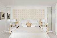 a white bedroom with a large bed and two lamps at Four Seasons Hotel George V Paris in Paris