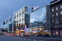 a large glass building with cars parked in front of it at Park Inn by Radisson Central Tallinn in Tallinn