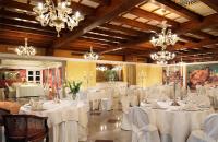 a banquet hall with white tables and chairs and chandeliers at Villa Fiorita in Monastier di Treviso