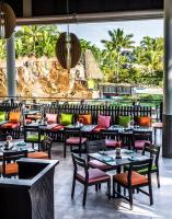 デナラウにあるラディソン ブルー リゾート フィジーのテーブルと椅子があり、海が見えるレストラン