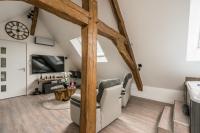 an attic living room with a large wooden beam at Suite Cupidon- Domaine des trois châteaux in Moisenay