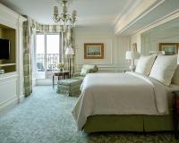 a bedroom with a large bed and a living room at Four Seasons Hotel George V Paris in Paris