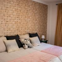 a bedroom with a brick wall and a bed with pillows at Hostal Caminito del Rey in Alora
