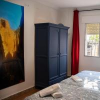 a bedroom with a blue cabinet next to a painting at Hostal Caminito del Rey in Alora