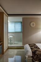 a bedroom with a bed and a shower and a clock at HL53 B&amp;B in Hualien City