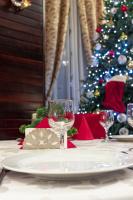 a table with a wine glass on a table with a christmas tree at Pensiunea Splendid in Dorohoi