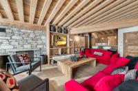 a living room with red furniture and a stone wall at Penthouse Chamois - LES CHALETS COVAREL in La Daille