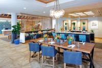 a dining room with a long table and blue chairs at Hotel Indigo Orange Beach - Gulf Shores by IHG in Gulf Shores