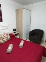 a bedroom with a red bed with a black chair at Citadel View Studio Penthouse in Kerċem