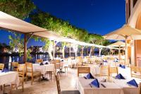 um restaurante com mesas brancas, cadeiras e guarda-sóis em Three Corners Ocean View El Gouna - Adults Only em Hurghada