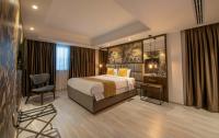 ニコシアにあるAlmond Business Hotelのベッドと椅子のあるホテルの部屋