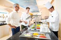 Três chefs numa cozinha a preparar comida. em Three Corners Ocean View El Gouna - Adults Only em Hurghada
