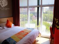 ZhangjiakouにあるShell Zhangjiakou City Qiaodong District Ginza Hotelのベッドと大きな窓のある寝室