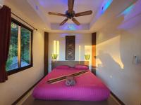 a bedroom with two beds and a ceiling fan at Moonstone Studio in Haad Rin