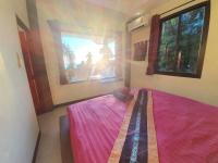 a bedroom with a pink bed and a window at Moonstone Studio in Haad Rin