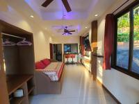 a room with a couch and a ceiling fan at Moonstone Studio in Haad Rin