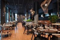 una sala da pranzo con tavoli, sedie e lampadari di Quality Hotel River Station a Drammen