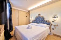 a bedroom with a bed with a blue and white headboard at Hotel Vecellio Venice on the Lagoon in Venice