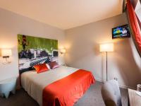 a hotel room with a bed and a flat screen tv at Hôtel Harvey in Paris