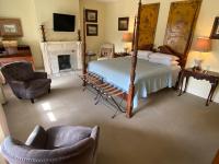 a bedroom with a bed and a chair and a fireplace at Foley House Inn in Savannah