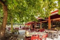 a patio with tables and chairs under a tree at Badhotel Rockanje in Rockanje