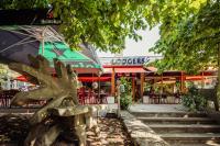 a bench in front of a restaurant with an umbrella at Badhotel Rockanje in Rockanje
