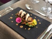 un plato negro con comida en una mesa en Hotel Restaurant Du Parc Saumur Logis Elégance, en Saumur