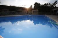 a swimming pool with blue water in front of a house at Dortoirs Rocade 2 in Pamiers