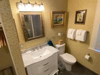 a bathroom with a sink and a toilet and a mirror at Foley House Inn in Savannah