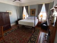 a bedroom with a bed and a couch and windows at Foley House Inn in Savannah