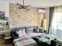 a living room with a couch and a brick wall at Cocoon vue Mer ☆ en face du Port de Golfe-Juan ☆ in Golfe-Juan