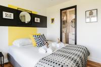 a bedroom with a white bed and a mirror at GuestReady - Charming studio in Issy-les-Moulineaux in Issy-les-Moulineaux