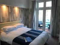 a bedroom with a bed with a book on it at Shellseekers Guest House in Looe