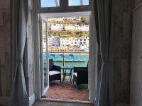 a room with a view of a pool and a table at Shellseekers Guest House in Looe