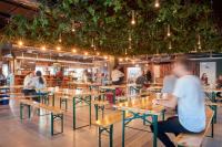 コペンハーゲンにあるUrban Camper Hostel &amp; Barのレストランのテーブルに座っている人々のグループ