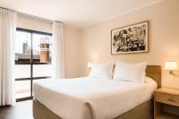Un dormitorio con una cama y una ventana grande. en Alfa Suites - Montevideo, en Montevideo