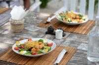 un tavolo con due piatti di cibo sopra di Scar Reef Resort - Beachfront Paradise HALF BOARD or NIGHT STAY a Jereweh