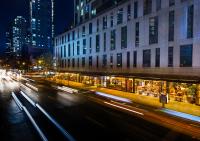 Una calle de la ciudad por la noche con edificios y luces. en Kimpton Hotel Eventi by IHG, en Nueva York