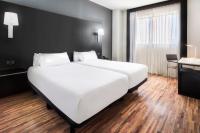 Una gran cama blanca en una habitación de hotel. en B&amp;B HOTEL Madrid Getafe, en Getafe