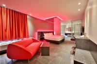 Habitación roja con cama y sofá en Hôtel Ô Laval, en Laval