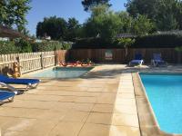 a swimming pool with blue chairs and a fence at Mobil home PREMIUM 35m2 3 chambres 6 personnes in Arès