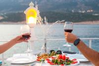 two people holding glasses of wine at a table with food at Club Çapa Hotel in Kas