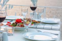 a table with glasses of wine and a plate of food at Club Çapa Hotel in Kas