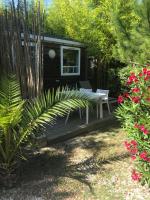 une terrasse en bois avec une table de pique-nique et quelques fleurs dans l&#39;établissement Eco-Lodge Lou Pantaï, au Pradet