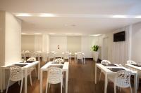 uma sala de jantar com mesas e cadeiras brancas em King Motel王者 em Taoyuan