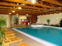 a large swimming pool with chairs and a table at Wellness Hotel Happy Star in Hnanice