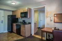 una pequeña cocina con nevera negra y mesa en Candlewood Suites Windsor Locks by IHG, en Windsor Locks