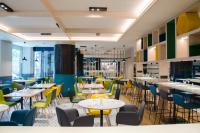 Un restaurante con mesas y sillas en una sala. en Suites Plaza Hotel & Wellness, en Andorra la Vella