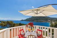 a table with chairs and an umbrella on a balcony at Apartments More in Sobra